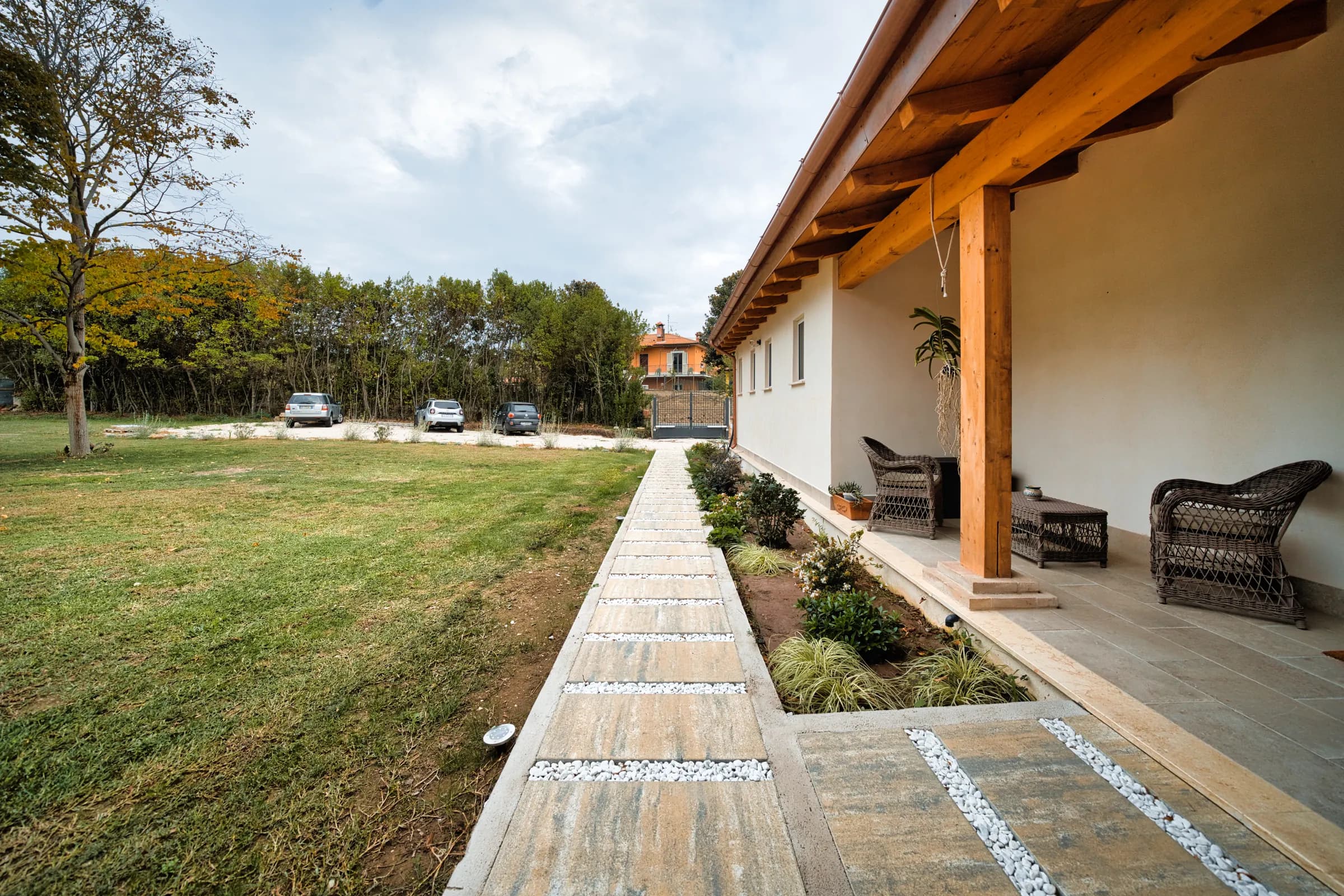 Vialetto in pietra lungo il portico, con tavolino e poltrone