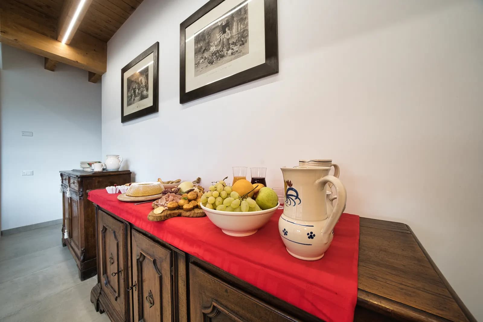 Buffet della colazione con frutta, dolci e caraffe in ceramica