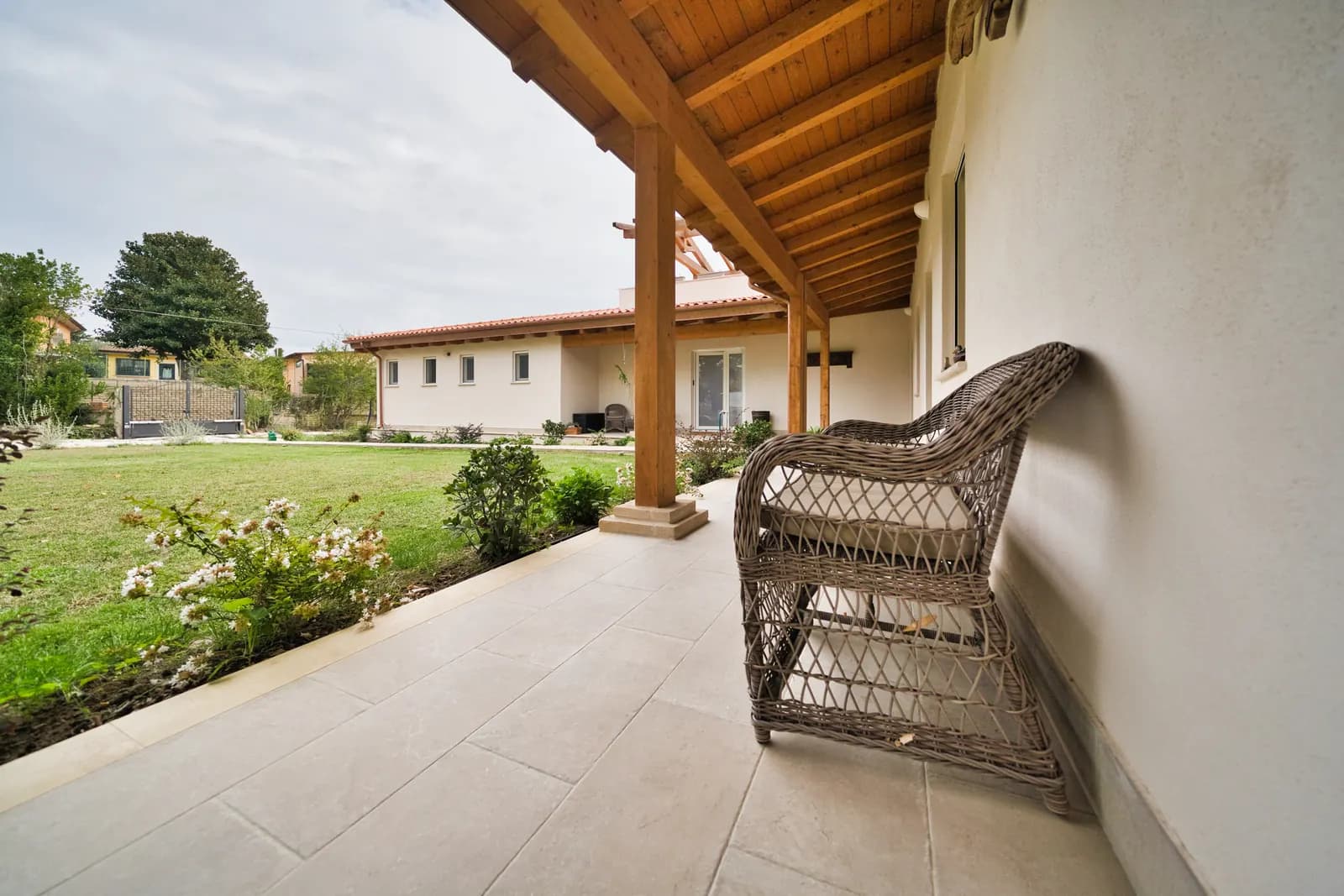 Poltrona in vimini sotto il portico, con vista sul giardino